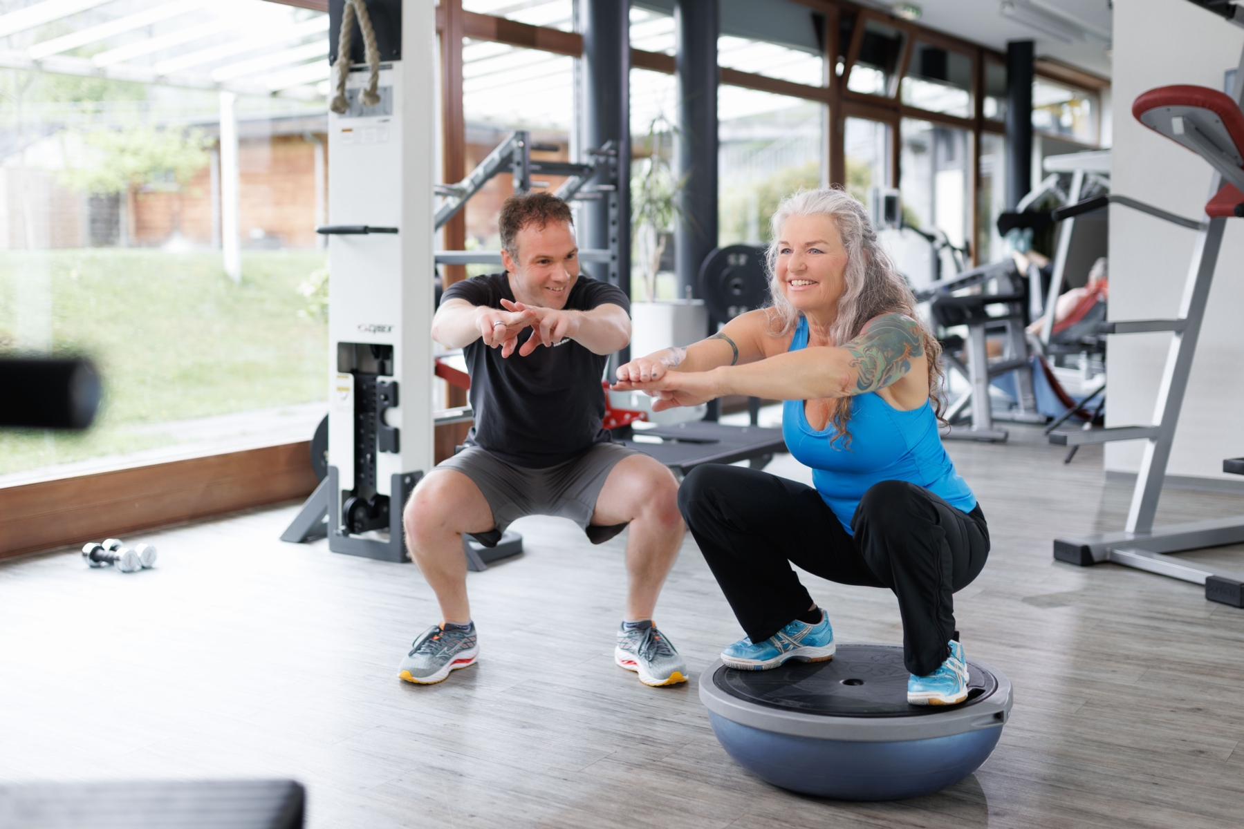 Trainer beim instruieren einer koordinativen Übung auf dem Bosuball in Frutigen